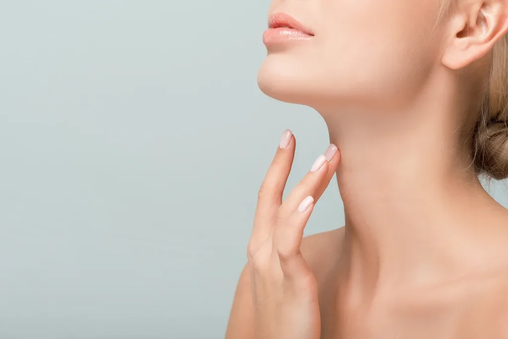 A close up shot of a woman touching her neck after getting neck band treatment with BOTOX