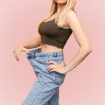 A woman wearing a baggy pair of jeans, showing the concept of fat loss from CoolSculpting