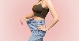 A woman wearing a baggy pair of jeans, showing the concept of fat loss from CoolSculpting